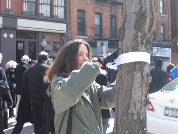 Vera House Executive Director Randi Bregman ties a white ribbon.
